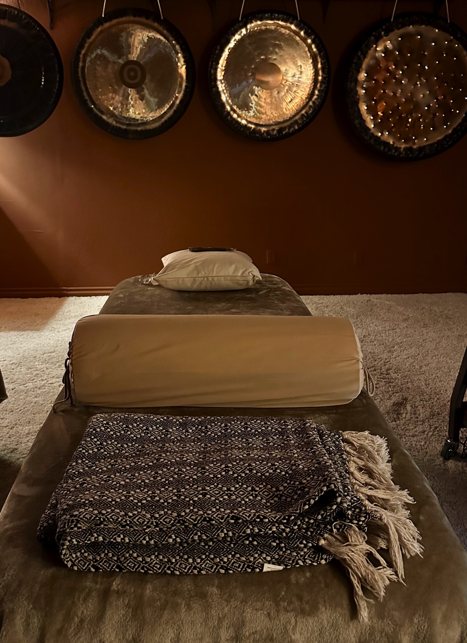 The Gong Room Private Sound Bath Setup with massage table and gongs