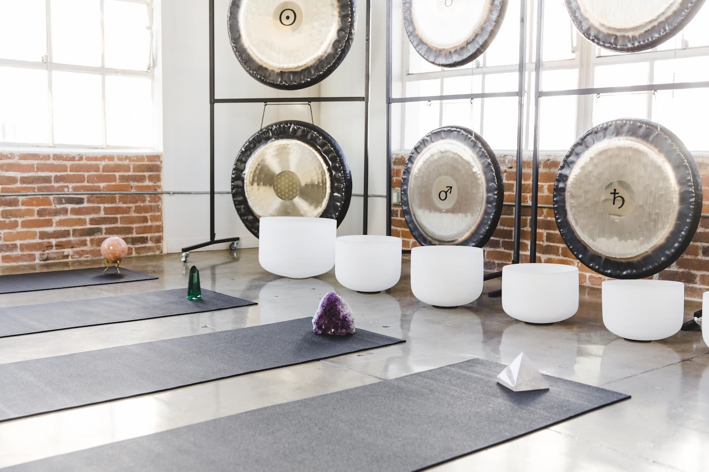 sound bath setup with gongs crystal bowls and crystals